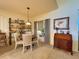 Cozy dining area with a round table, four chairs, decorative shelf, and a window with natural light at 1402 Colonial Ct, Winter Haven, FL 33884