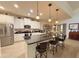 Bright kitchen with a granite island, pendant lighting, stainless appliances, and white cabinets at 1402 Colonial Ct, Winter Haven, FL 33884