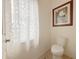 Cozy powder room with a modern toilet and bright natural light from the window at 1402 Colonial Ct, Winter Haven, FL 33884