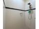 Updated shower features stylish black accent tiles and a convenient shower caddy at 1402 Colonial Ct, Winter Haven, FL 33884