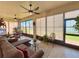 Bright sunroom featuring tile floors, ceiling fans, and views of the backyard at 1402 Colonial Ct, Winter Haven, FL 33884