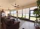 Bright sunroom with many windows, ceiling fans and cozy seating for relaxation and entertainment at 1402 Colonial Ct, Winter Haven, FL 33884