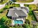 Aerial view showcasing a backyard pool with screened enclosure and lush landscaping, providing a private outdoor oasis at 1409 Berkley Ct, Winter Haven, FL 33880