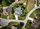 A high angle aerial view of a home with green grass, nearby swimming pool, and circular streets at 1409 Berkley Ct, Winter Haven, FL 33880