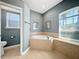 Relaxing bathroom featuring a soaking tub with tile surround and a window that provides natural light at 1409 Berkley Ct, Winter Haven, FL 33880