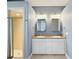 Bright bathroom featuring a double vanity, framed mirrors, and a glass shower with neutral tiling at 1409 Berkley Ct, Winter Haven, FL 33880