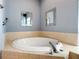 Close up of a bathtub with tile surround, featuring chrome fixtures and decorative mirrors at 1409 Berkley Ct, Winter Haven, FL 33880