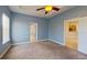 Bedroom with neutral walls, carpet, and a tray ceiling and two entryways at 1409 Berkley Ct, Winter Haven, FL 33880