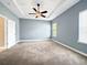 Spacious carpeted bedroom featuring a tray ceiling with fan and natural light from the large window at 1409 Berkley Ct, Winter Haven, FL 33880