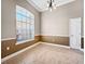 Cozy dining room with a large window, chandelier, and neutral wall colors with chair rail at 1409 Berkley Ct, Winter Haven, FL 33880