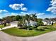 Charming home featuring a well-manicured lawn, mature palm trees, and a three-car garage at 1409 Berkley Ct, Winter Haven, FL 33880