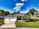 Beautifully landscaped home showcasing a long driveway, three-car garage and meticulously maintained lawn at 1409 Berkley Ct, Winter Haven, FL 33880