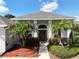 Inviting home exterior featuring well-maintained landscaping, palm trees, and a defined walkway to the front door at 1409 Berkley Ct, Winter Haven, FL 33880
