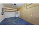A garage with a blue floor, an exterior door, and exposed shelving at 1409 Berkley Ct, Winter Haven, FL 33880