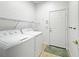 Laundry room with appliances, storage, and tile floor at 1409 Berkley Ct, Winter Haven, FL 33880