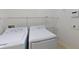 A laundry room with white washer and dryer, and wire shelving at 1409 Berkley Ct, Winter Haven, FL 33880