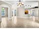 Bright and spacious living room with tile flooring, ceiling fan, and views into the kitchen and dining area at 1409 Berkley Ct, Winter Haven, FL 33880