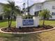Lake Buckeye Condominiums with a well-maintained lawn, landscaping, and palm trees in a sunny Florida community at 1550 11Th Ne St # A2, Winter Haven, FL 33881
