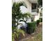 An exterior view showcases the condo's architecture, landscaping, and outdoor AC unit at 1550 11Th Ne St # A2, Winter Haven, FL 33881