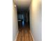 Hallway features new laminate flooring and grey walls leading to living room with fan and screened patio at 1550 11Th Ne St # A2, Winter Haven, FL 33881