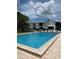 Large community swimming pool is surrounded by lounge chairs and has a view of the lake at 1550 11Th Ne St # A2, Winter Haven, FL 33881