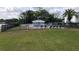 A gated community pool area is surrounded by lush landscaping and a grassy lawn at 1550 11Th Ne St # A2, Winter Haven, FL 33881