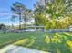 Beautiful backyard with grassy area, deck, white picket fence, and water access at 167 Bonnie Dr, Auburndale, FL 33823