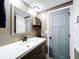 Bathroom featuring a vanity with white countertop, a mirror, cabinet, and a gray door at 167 Bonnie Dr, Auburndale, FL 33823