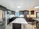 Open kitchen featuring modern stainless appliances, quartz countertops, and dark wood cabinets at 167 Bonnie Dr, Auburndale, FL 33823