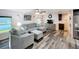 Comfortable living room with wood-look floors, ceiling fan, and a gray sectional sofa with ottoman at 167 Bonnie Dr, Auburndale, FL 33823