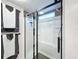 Modern walk-in shower with glass doors, built-in shelves, and black hardware, offering a luxurious experience at 167 Bonnie Dr, Auburndale, FL 33823