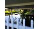 A serene canal view with boat dock is seen from under a covered patio and through a white picket fence at 167 Bonnie Dr, Auburndale, FL 33823