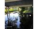 Canal view from under a covered patio, showing boat dock with reflections in water at 167 Bonnie Dr, Auburndale, FL 33823
