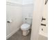 Clean, bright bathroom featuring a modern toilet, white wainscoting, and decorative accents at 169 Summershore Dr, Auburndale, FL 33823