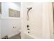 Bathroom showcasing a white tiled shower and tub combination with sleek black fixtures and art at 169 Summershore Dr, Auburndale, FL 33823