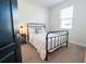 Bedroom showcasing a black iron bed frame, side table with lamp, and large window with blinds at 169 Summershore Dr, Auburndale, FL 33823