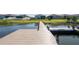 View of a modern dock extending onto a calm, blue lake, adding waterfront charm at 169 Summershore Dr, Auburndale, FL 33823