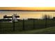 Beautiful sunset view of the community dock with seating by the lake at 169 Summershore Dr, Auburndale, FL 33823
