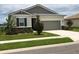 Charming single-story home with a well-manicured lawn, appealing landscaping, and an attached two-car garage at 169 Summershore Dr, Auburndale, FL 33823