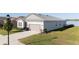 Beautiful single-Gathering home with gray stucco, stone accents, attached garage, and lovely lawn at 169 Summershore Dr, Auburndale, FL 33823