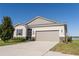 Charming single-story home featuring a two-car garage and beautifully landscaped front yard on a clear, sunny day at 169 Summershore Dr, Auburndale, FL 33823