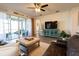 Bright living room showcasing a ceiling fan, entertainment center, and sliding door access to the patio at 169 Summershore Dr, Auburndale, FL 33823