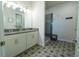 Elegant bathroom with double vanity, modern tile floors, and glass-enclosed shower at 169 Summershore Dr, Auburndale, FL 33823