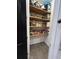 Well-organized walk-in pantry with rustic wooden shelves and plenty of storage for food items and kitchen appliances at 169 Summershore Dr, Auburndale, FL 33823
