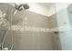 Walk-in shower featuring grey tile and a dual shower head fixture at 169 Summershore Dr, Auburndale, FL 33823
