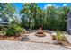 A backyard firepit area with brick pavers, chairs, and mature landscaping providing privacy at 2 Bridgewater Dr, Winter Haven, FL 33884
