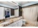 Bathroom has a double sink vanity with granite counters and a shower with curtain at 2 Bridgewater Dr, Winter Haven, FL 33884