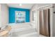 Bright bathroom features a tub and shower combination with white tile and a window at 2 Bridgewater Dr, Winter Haven, FL 33884