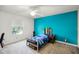 Vibrant bedroom with bright blue accent wall, window, and cozy bed at 2 Bridgewater Dr, Winter Haven, FL 33884
