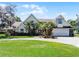 Charming two-story home featuring a spacious front yard, palm trees, and an attached two-car garage at 2 Bridgewater Dr, Winter Haven, FL 33884